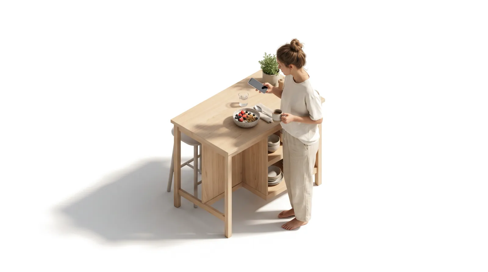 A woman at a kitchen island photographing her breakfast bowl while holding a coffee